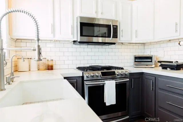a kitchen with stainless steel appliances a stove a microwave sink and cabinets