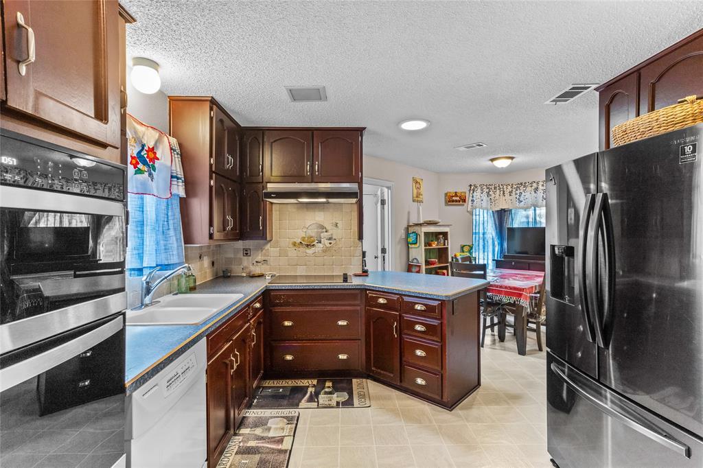 2626 Collard Road Arlington, TX 76017 - Photo 27 of 40 a kitchen with stainless steel appliances granite countertop a refrigerator and a stove top oven
