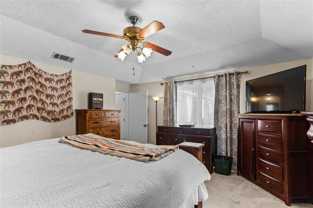 2626 Collard Road Arlington, TX 76017 - Photo 35 of 40 a bedroom with a bed and a flat screen tv