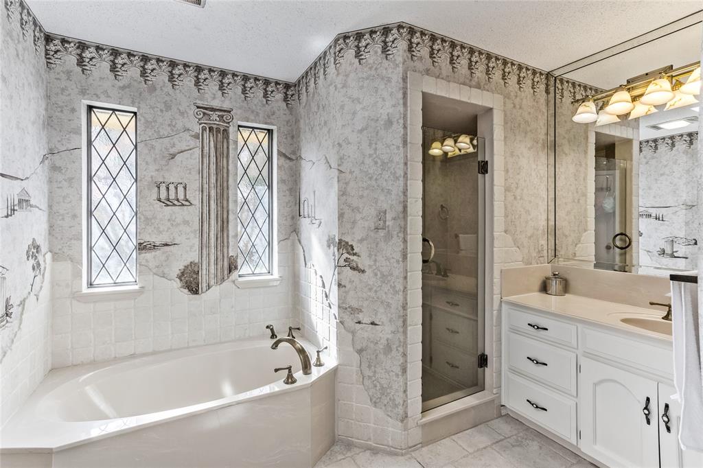 2626 Collard Road Arlington, TX 76017 - Photo 38 of 40 a bathroom with a bathtub a shower a sink and a large mirror