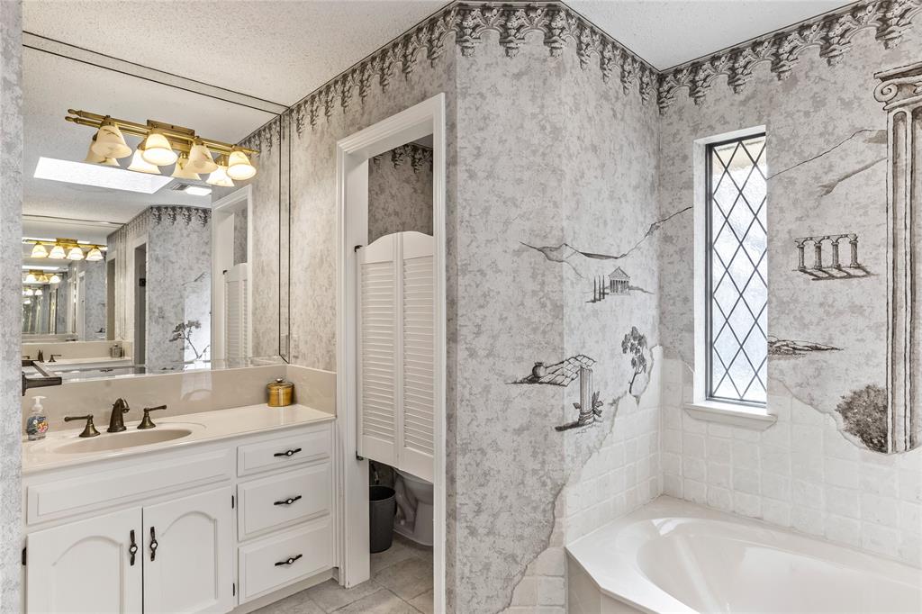 2626 Collard Road Arlington, TX 76017 - Photo 40 of 40 a bathroom with a granite countertop sink a mirror a bathtub and shower