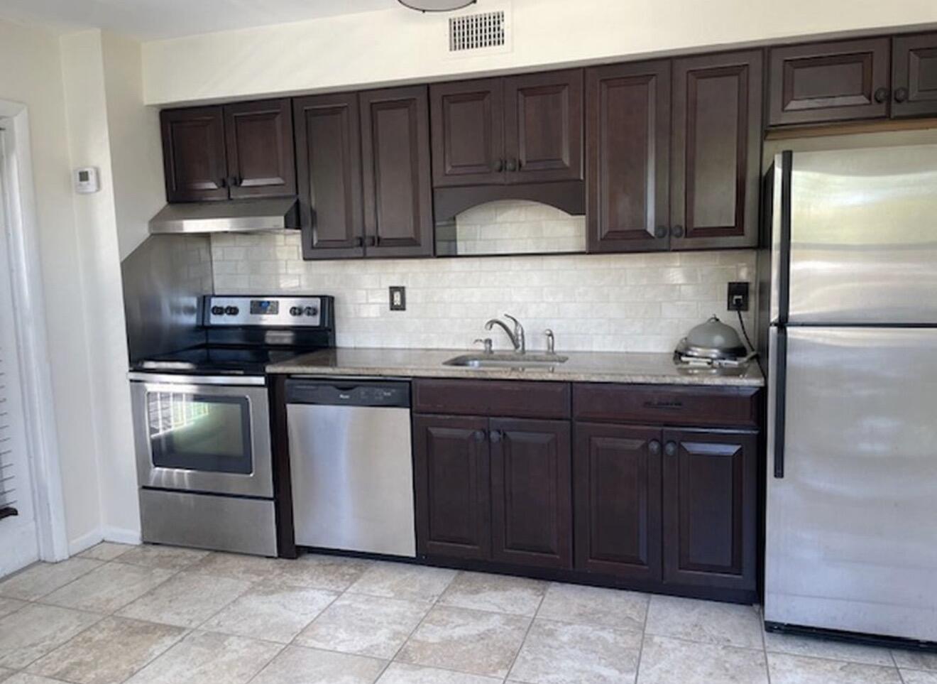 220 Inlet Way, Unit 3 Palm Beach Shores, FL 33404 - Photo 3 of 16 a kitchen with a refrigerator and cabinets