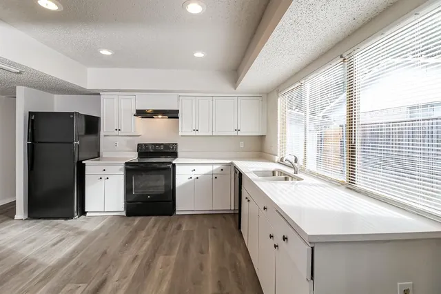 a kitchen with a sink a refrigerator and a stove
