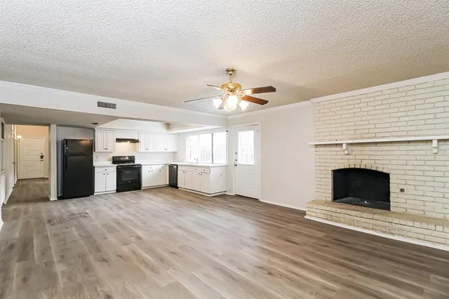 a view of a kitchen with a sink a fireplace and window