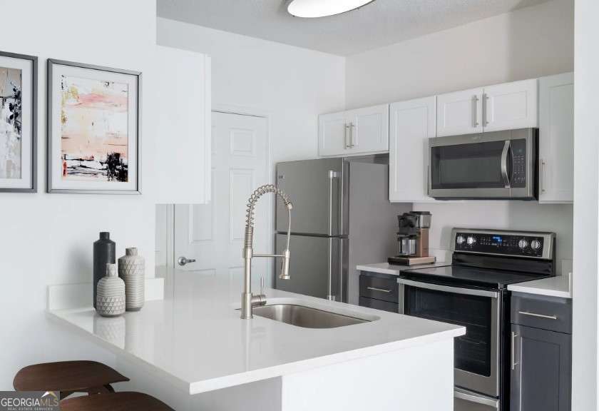 a kitchen with stainless steel appliances a refrigerator a sink a stove and cabinets