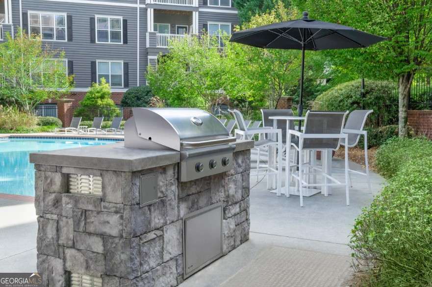 2500 Shallowford Road, Unit 4403 Atlanta, GA 30345 - Photo 13 of 20 a view of a patio with a table and chairs under an umbrella