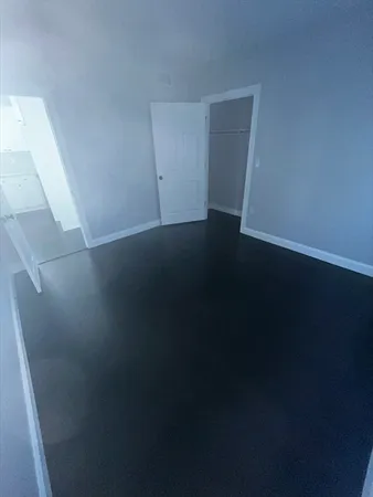 a view of empty room with window and wooden floor