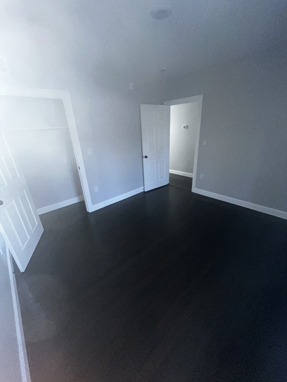 3927 Washington Street, Unit 2 Boston, MA 02131 - Photo 5 of 9 a view of an empty room with wooden floor