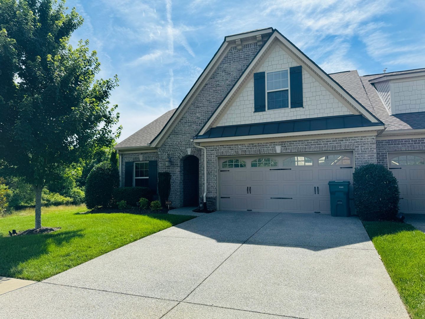 a front view of a house with a yard and trees