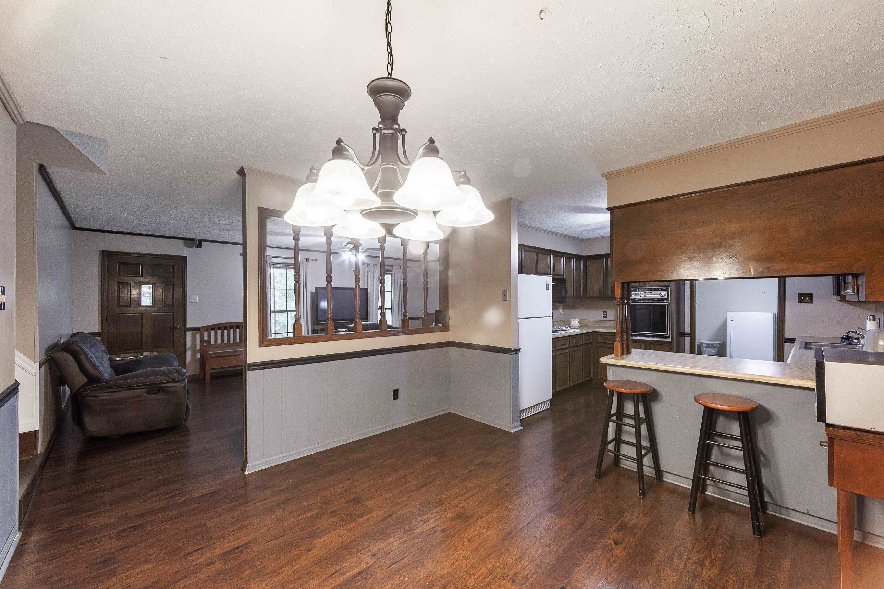 823 Potts Chapel Road Jackson, TN 38305 - Photo 8 of 24 a kitchen with stainless steel appliances wooden floor dining table and chairs