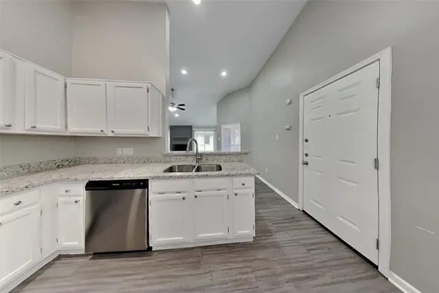 a kitchen with stainless steel appliances granite countertop a stove a sink and a white refrigerator