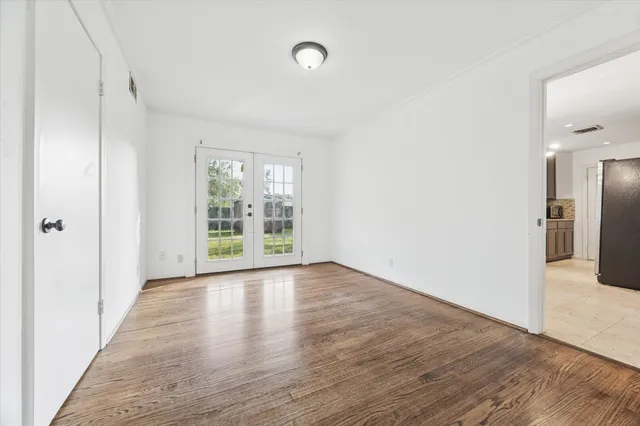 a view of a big room with wooden floor and windows