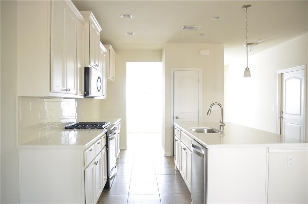 14403 McCoy Loop Austin, TX 78717 - Photo 8 of 29 A well-appointed galley kitchen with gleaming countertops and integrated appliances awaits culinary exploration.