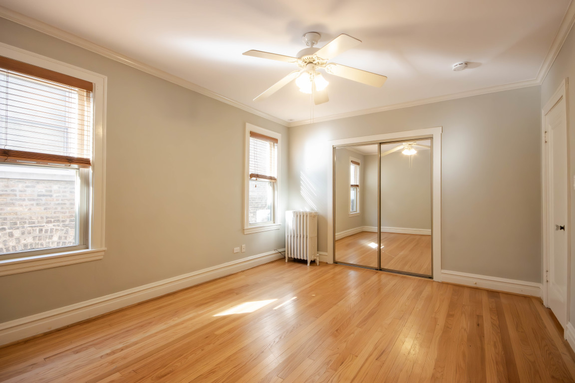 1122 Hull Terrace, Unit 2 Evanston, IL 60202 - Photo 12 of 17 an empty room with wooden floor and windows
