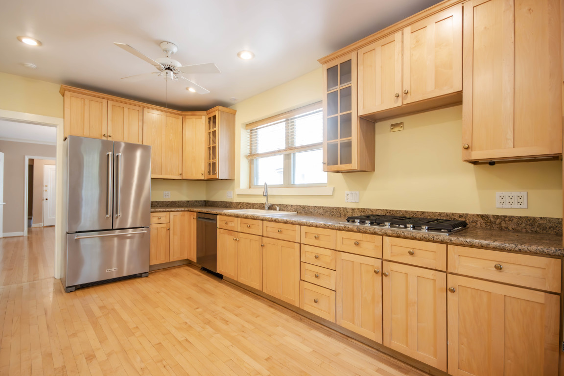 1122 Hull Terrace, Unit 2 Evanston, IL 60202 - Photo 9 of 17 a kitchen with granite countertop a refrigerator a sink and white cabinets