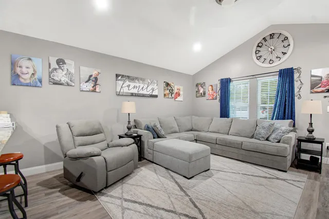 a living room with furniture a couch and paintings on the wall