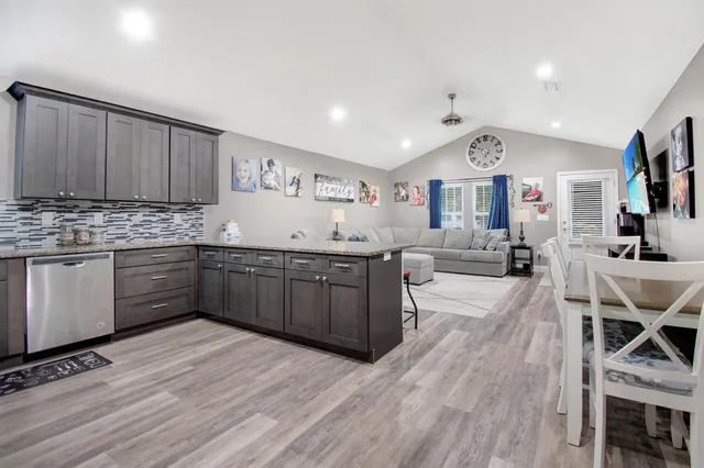 a kitchen with granite countertop a sink cabinets and wooden floor