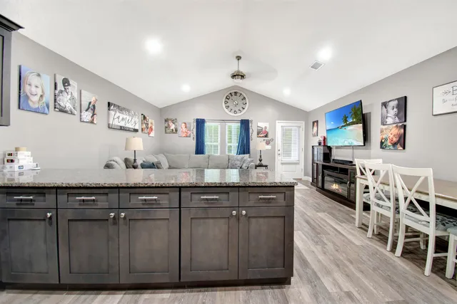 a spacious kitchen with stainless steel appliances granite countertop a stove and cabinets with wooden floor