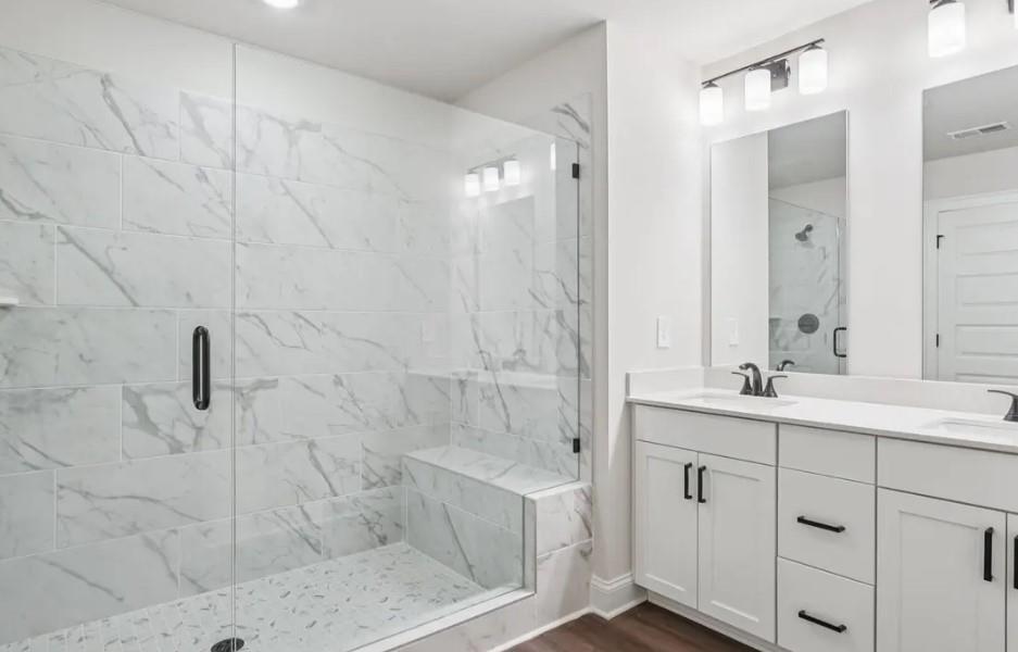 6390 Pinin Place Cumming, GA 30041 - Photo 11 of 14 a bathroom with a double vanity sink a mirror and shower