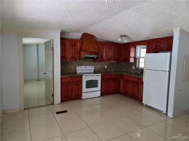 a kitchen with stainless steel appliances granite countertop a stove a refrigerator and a sink