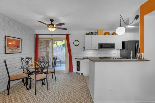 a kitchen with stainless steel appliances granite countertop a stove a sink and a dining table