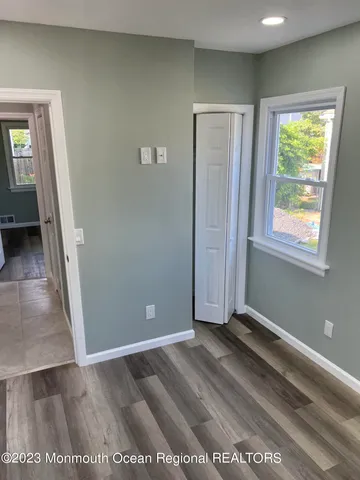 an empty room with windows and closet