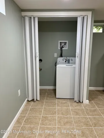 a room with a washing machine and a rug