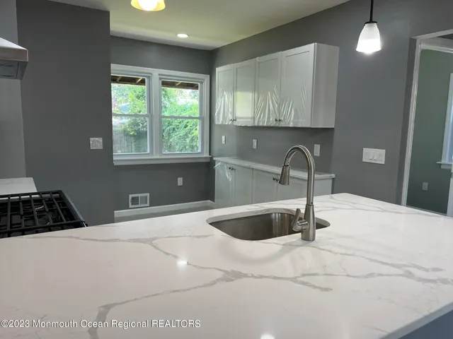 a kitchen with a sink a window and cabinets