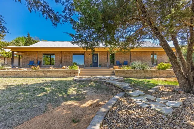 front view of a house with a large tree