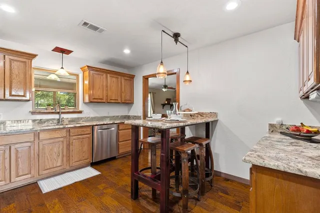 a kitchen with granite countertop wooden cabinets and center island