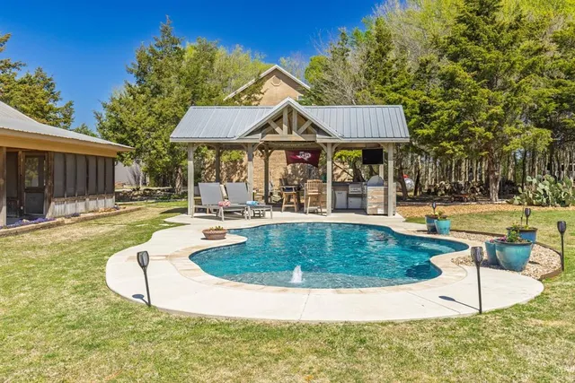 a view of a house with swimming pool and a yard