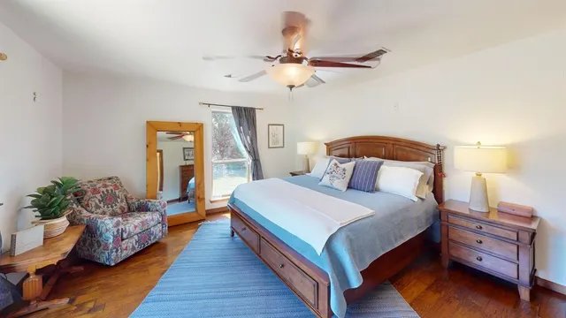 a bedroom with bed and wooden floor