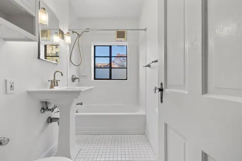 a bathroom with a tub a sink and mirror