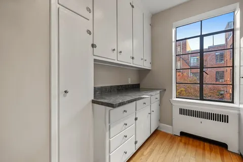 a kitchen with granite countertop white cabinets and a wooden floor