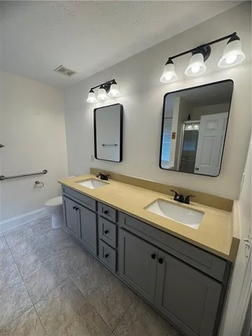 a bathroom with double vanity sink and a mirror