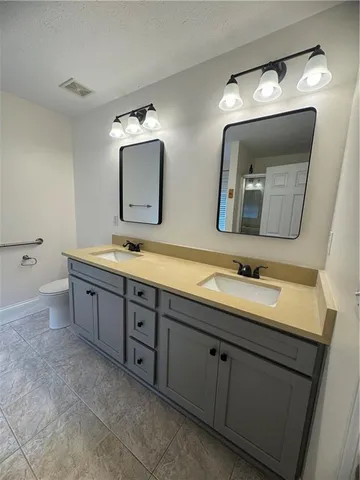 a bathroom with double vanity sinks and a mirror