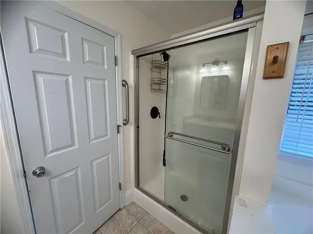 a bathroom with a glass shower door and sink