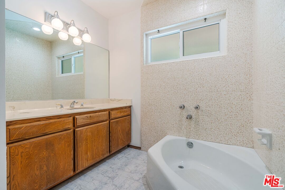 1181 Somera Road Los Angeles, CA 90077 - Photo 22 of 40 a bathroom with a tub sink and mirror