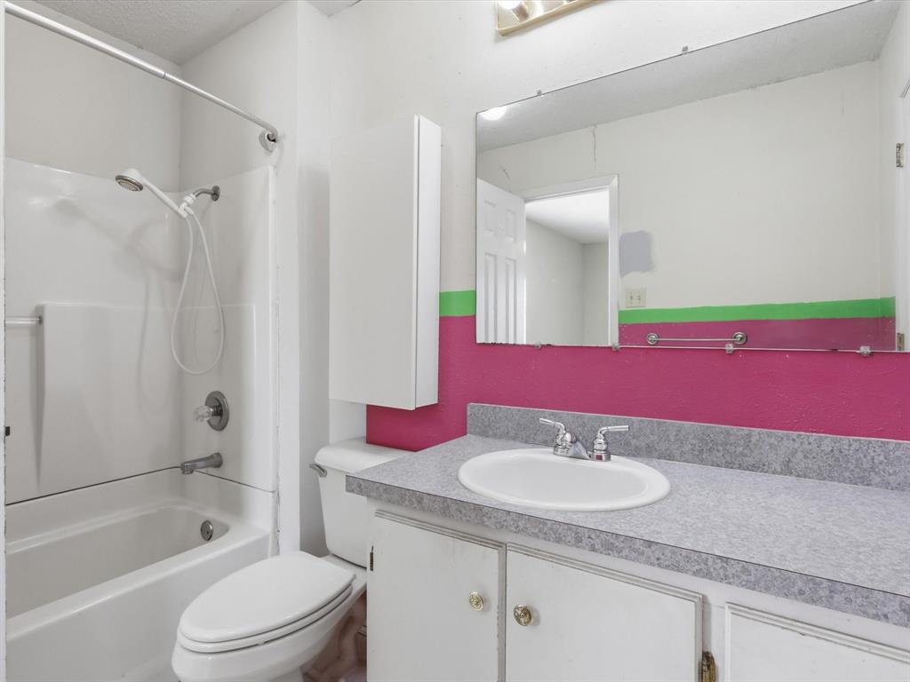 701 College Street Celeste, TX 75423 - Photo 17 of 29 a bathroom with a granite countertop sink a toilet and shower