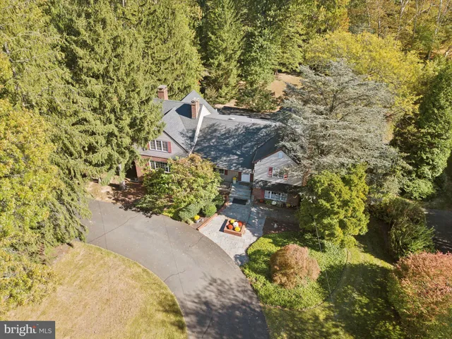 an aerial view of a house with a yard and large tree