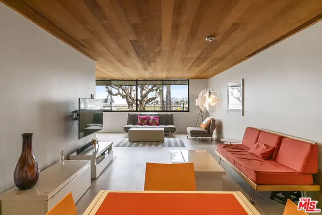 a living room with furniture wooden floor and a large window