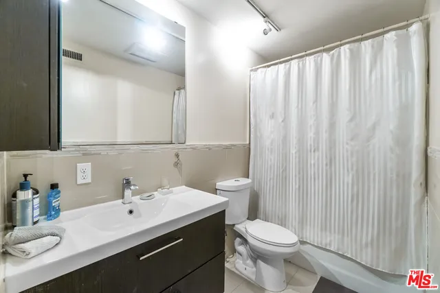 a bathroom with a sink vanity mirror and toilet