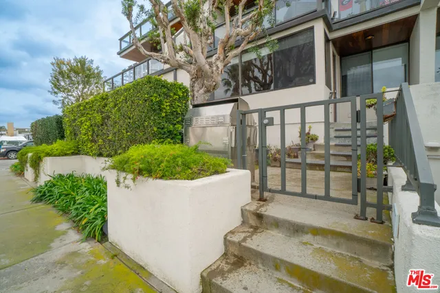 a view of a small house with potted plants