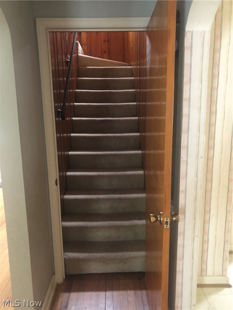 4037 Wilmington Road Cleveland, OH 44121 - Photo 24 of 36 Stairs featuring wood-type flooring and arched walkways