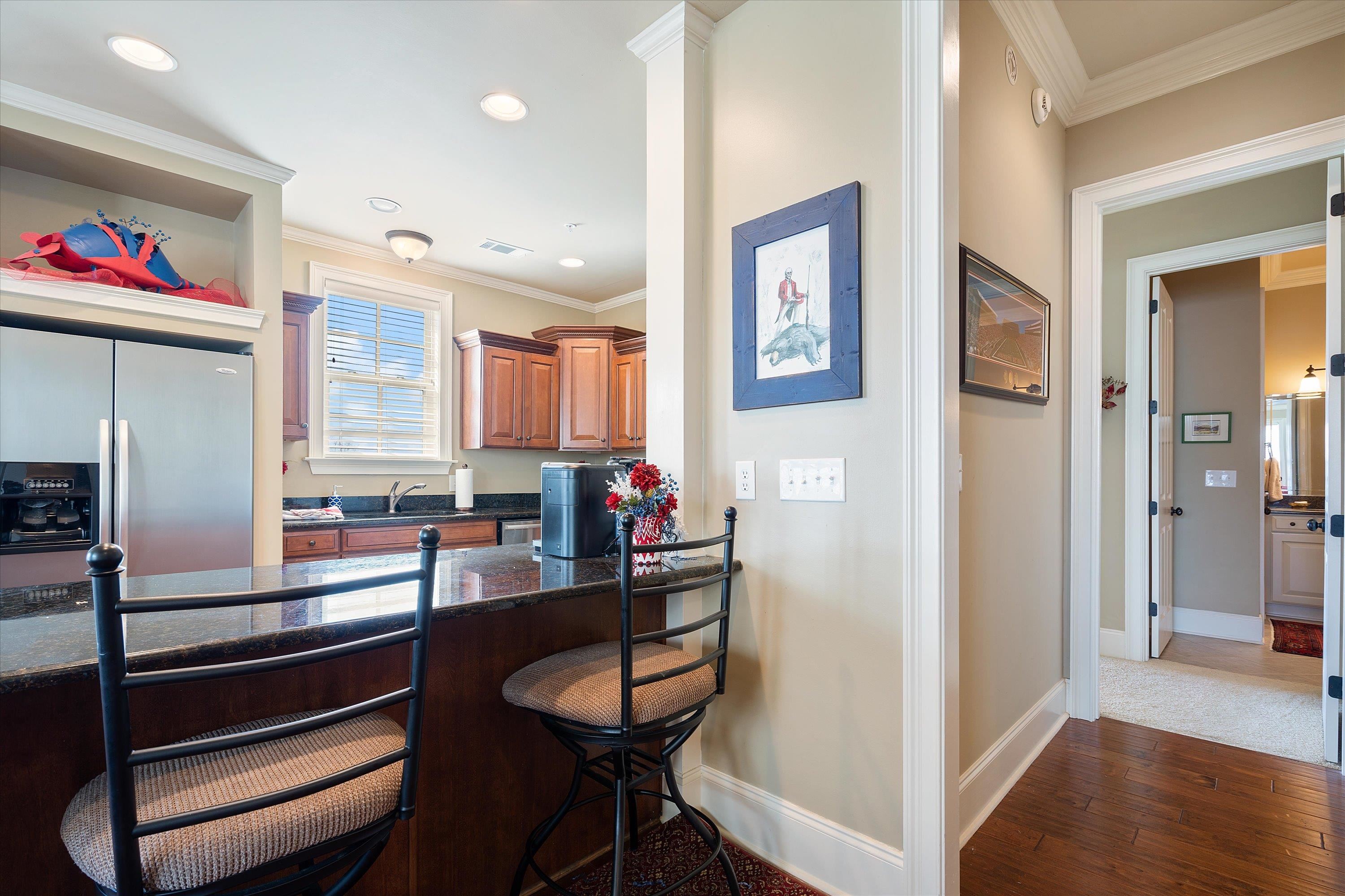 1100 Augusta Drive, Unit 103 Oxford, MS 38655 - Photo 9 of 24 a view of a dining room with furniture a chandelier and wooden floor