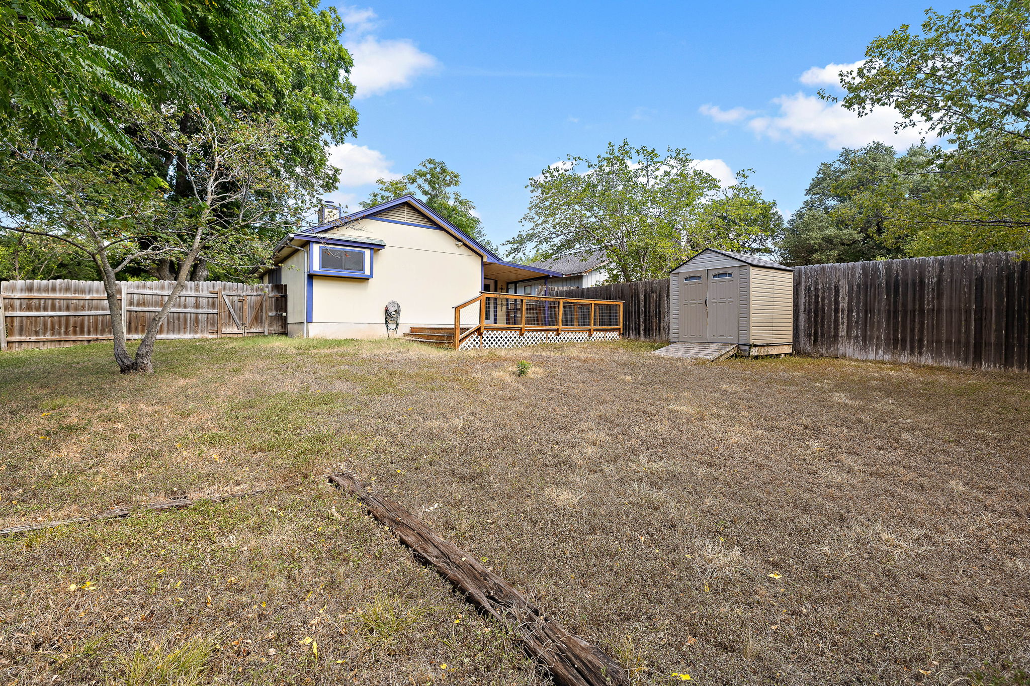 11709 Rotherham Drive Austin, TX 78753 - Photo 24 of 25 Rear facade with an inviting wooden deck, a spacious yard, and a handy storage shed.