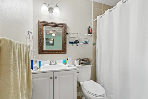 a bathroom with a toilet sink vanity and mirror
