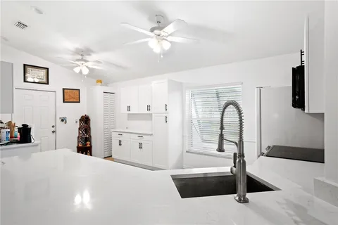 a living room with stainless steel appliances kitchen island furniture and a chandelier