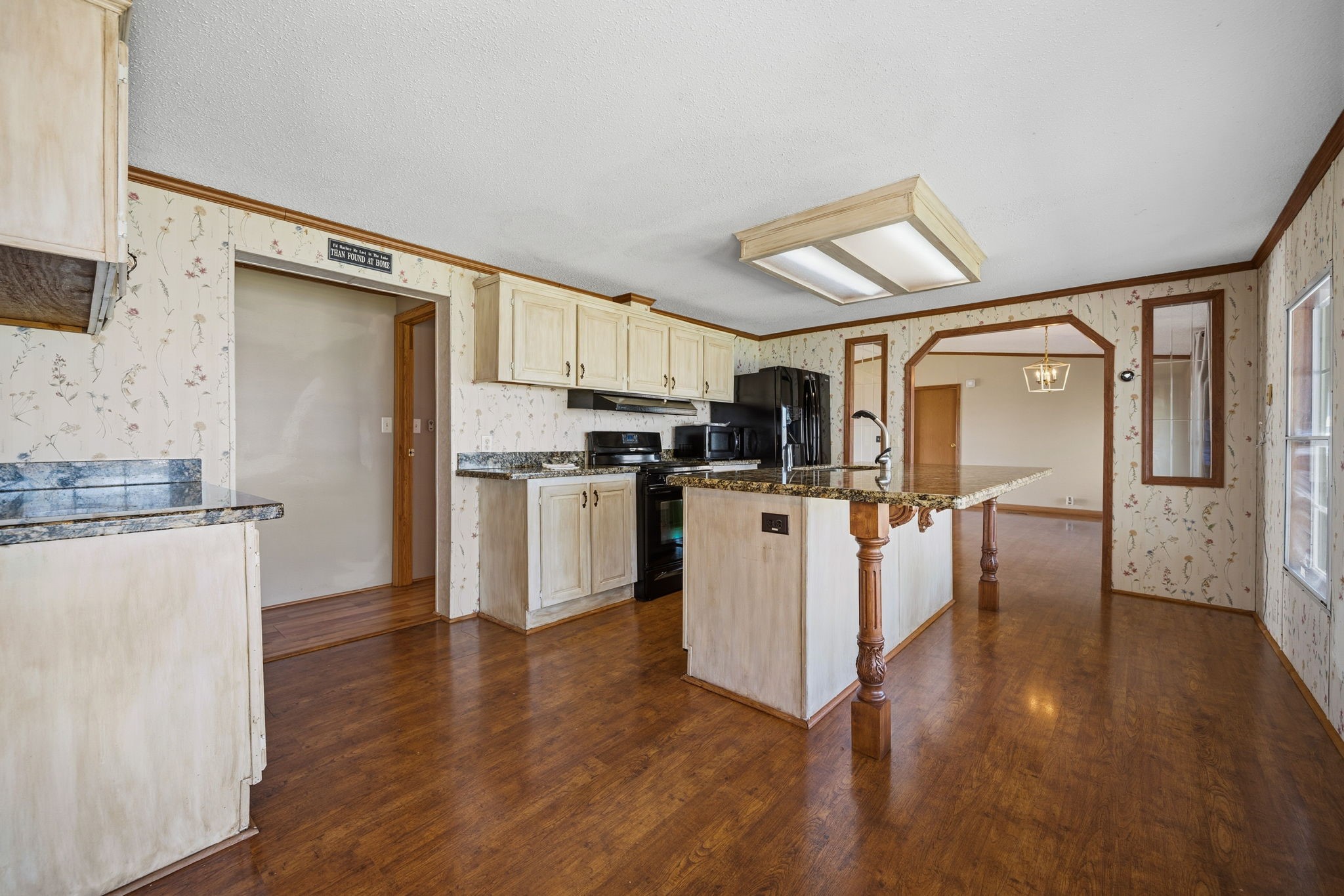 207 Vivian Road Onalaska, TX 77360 - Photo 18 of 33 Roomy kitchen with an abundance of cabinets and counter space. Island with sink. Breakfast area as well as breakfast bar for extra seating. Counter tops are granite. Gas cooking, fridge and microwave remain with the home.