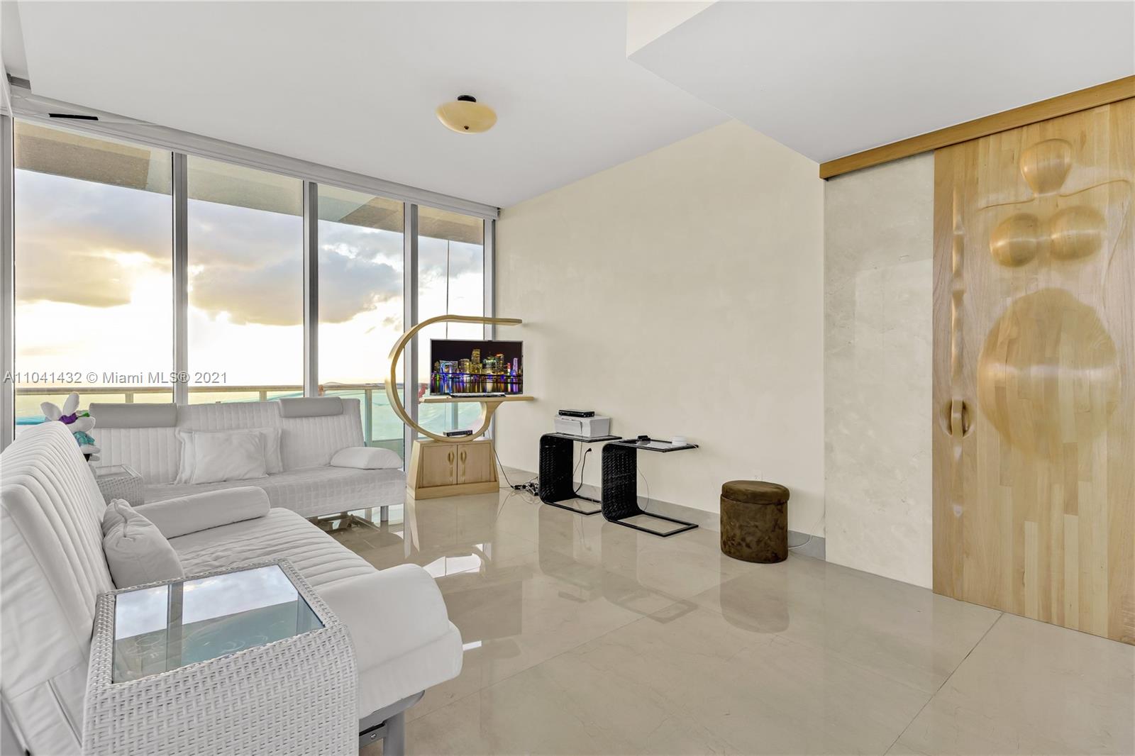 900 Biscayne Boulevard, Unit 6301 Miami, FL 33132 - Photo 34 of 72 a living room with furniture and a floor to ceiling window